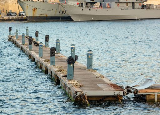 A view of a pontoon boat floating in a tranquil body of water in Pieta, Malta.