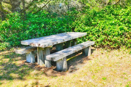 A shot of a wooden bench and table on grass
