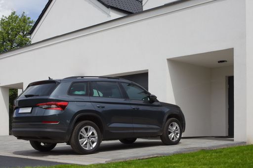 SUV car parked in front of a residence, apartment.