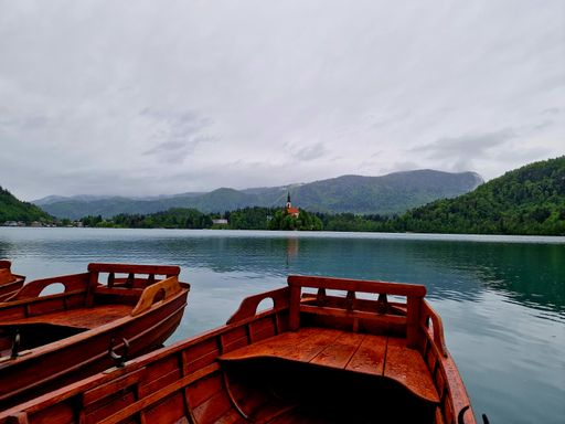 Lake Bled in Slovenia with an idyllic view of an island featuring the Church of the Mother of God on a cloudy day