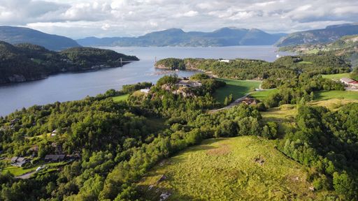 An aerial view of a tranquil lake surrounded by lush green mountains in West Norway