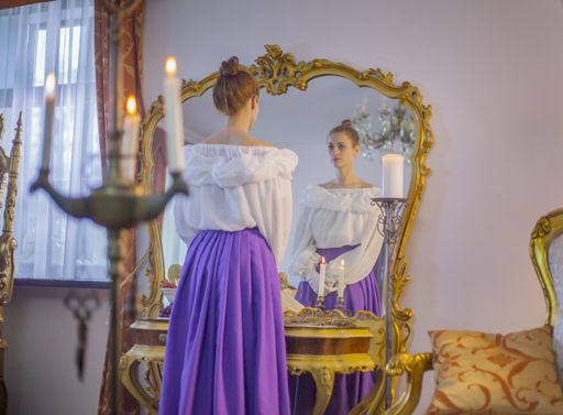 A Caucasian female standing in front of a mirror