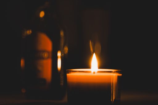 A closeup shot of a lit candle in the darkness.