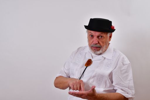 A view of an elderly man pointing to his other hand with his hand on a white background