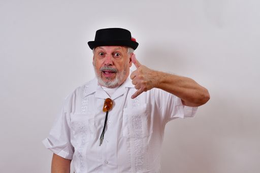 A view of an elderly man gesturing with his hand the sign of calling on a white background