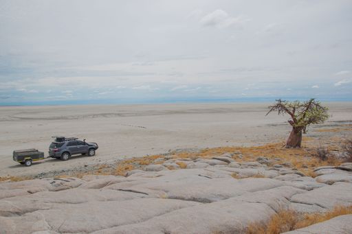 An off-road car driving down a desert road in Botswana