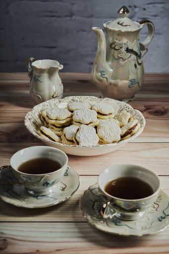 A composition with homemade biscuits with filling and vintage service set on the wooden table