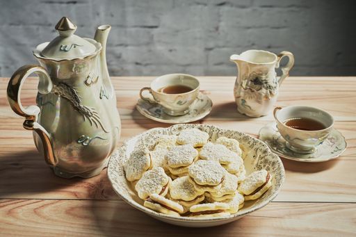 A composition with homemade biscuits with filling and vintage service set on the wooden table