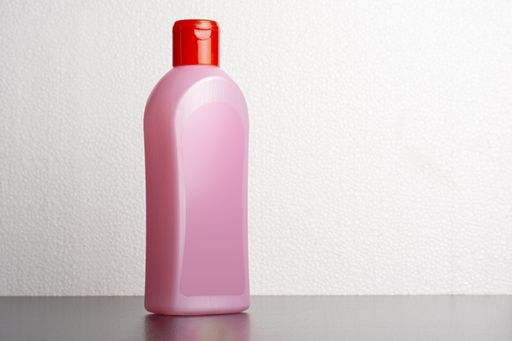A hair shampoo bottle in front of a light gray background, editable mock-up series ready for your design, selection path included.