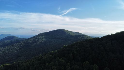 An aerial view of a stunning mountainous landscape featuring lush green trees and a peaceful atmosphere
