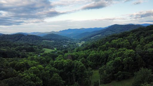 An aerial view of a stunning mountainous landscape featuring lush green trees and a peaceful atmosphere