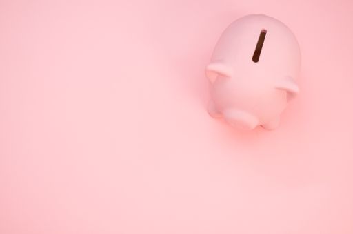 An overhead shot of a piggy bank on a pink background with space for your text - savings and banking concept