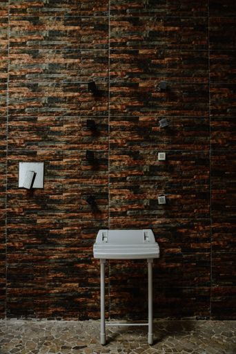 A vertical shot of loft-style chair on brick wall background