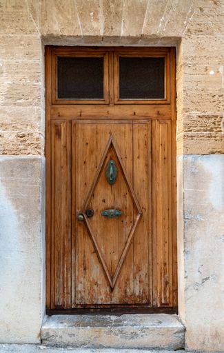 An intricate, rustic wooden door with a diamond-shaped design, Alcudia, Spain