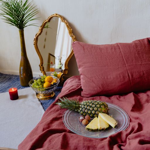 A cozy bedroom interior with fresh fruits, mirror, candle and plant in a vase