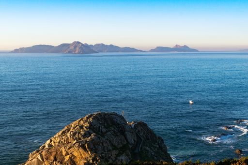 View of the punta lameda lighthouse in monteferro with the cies islands in the background on a summer day. Nigran - Spain.