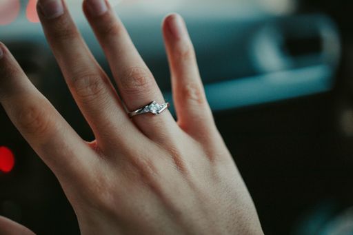 A closeup shot of a diamond proposition ring on female hands
