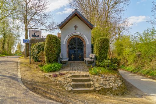 A beautiful view of a small chapel in the garden on a sunny day