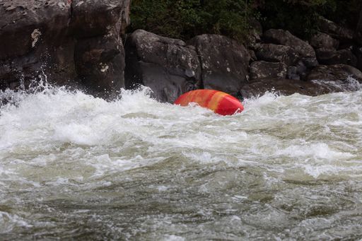 A group of people in a kayak navigating through the choppy waters of a river in Somerville, USA.