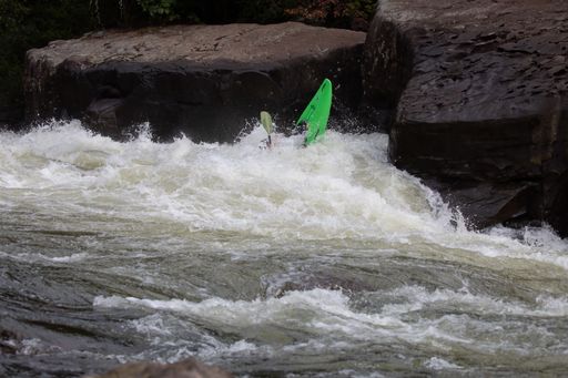 A group of people in a kayak navigating through the choppy waters of a river in Somerville, USA.