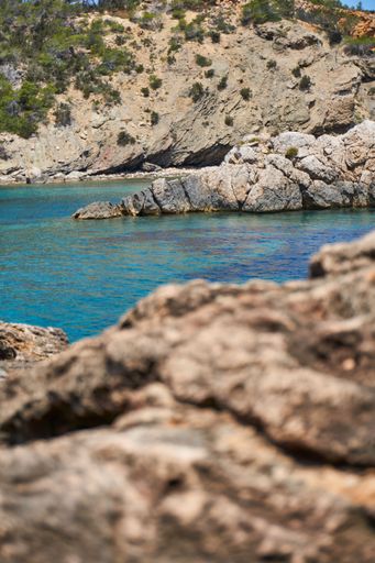 An idyllic seascape featuring large, rocky outcroppings at the shore of a tranquil sea