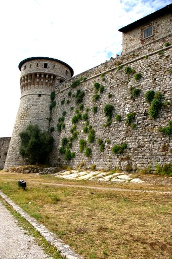 A low-angle shot of the castle of Brescia against the blue sky