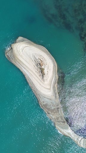 An aerial view of the rocky shoreline of Corfu, Greece with its crystal clear blue ocean waters.
