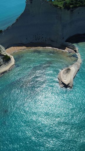 An aerial view of the rocky shoreline of Corfu, Greece with its crystal clear blue ocean waters.