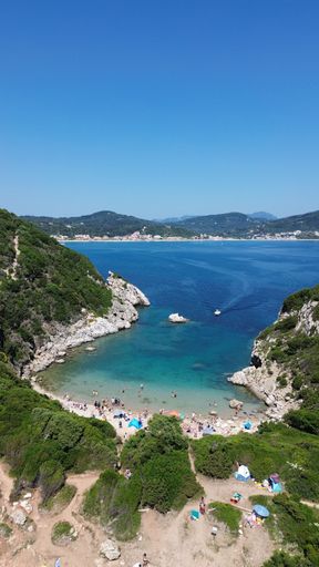 An aerial view of the rocky shoreline of Corfu, Greece with its crystal clear blue ocean waters.