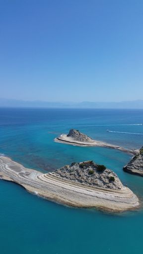 An aerial view of the rocky shoreline of Corfu, Greece with its crystal clear blue ocean waters.