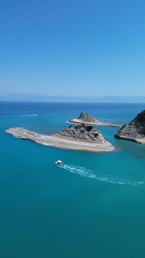 An aerial view of the rocky shoreline of Corfu, Greece with its crystal clear blue ocean waters.