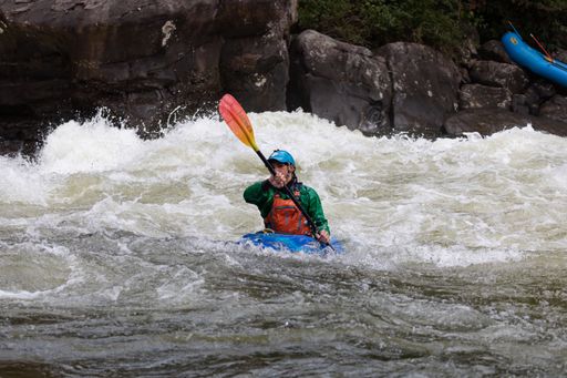 A person in a kayak navigating through the choppy waters of a river in Somerville, USA.