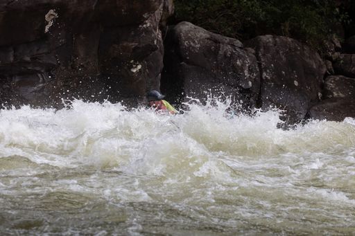 A group of people in a kayak navigating through the choppy waters of a river in Somerville, USA.