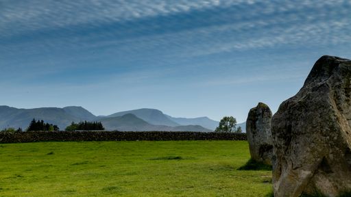 A landscape featuring large rocks in a grassy field