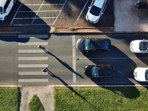 The cars on the road with a pedestrian crossing.