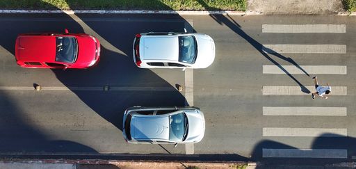The cars on the road with a pedestrian crossing.