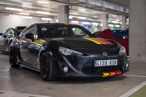 Front view of a black Toyota GT86 Japanese sports car with colored stripes parked in the underground parking