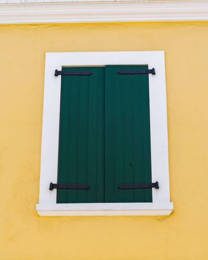 A vibrant window with a crisp white frame is featured against a sunny yellow wall