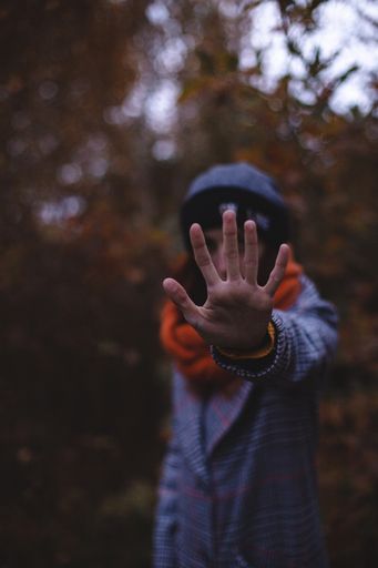 A vertical shot of a multiracial female covering her face with her palm
