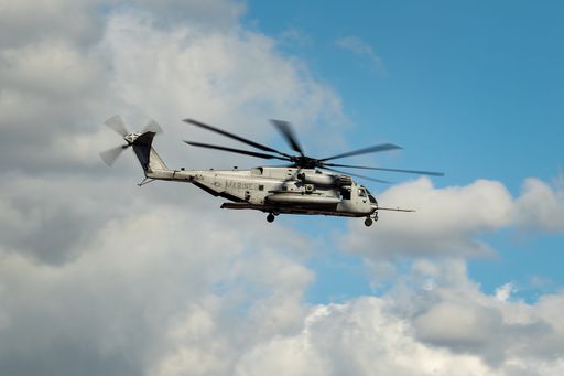 A U.S. navy marines helicopter flying through the sky on a cloudy day