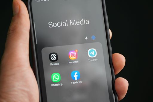 A man holding a smartphone with social media icons displayed on the screen