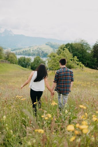 A vertical shot of a loving young couple walking in the field