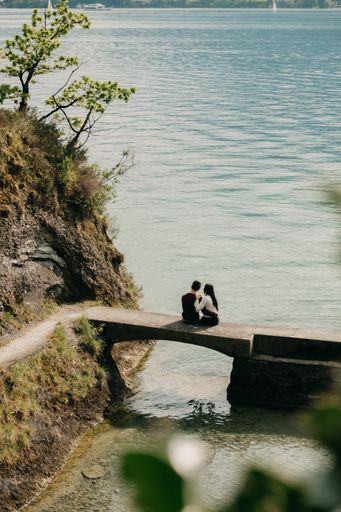 A romantic loving couple sitting on a small stone bridge