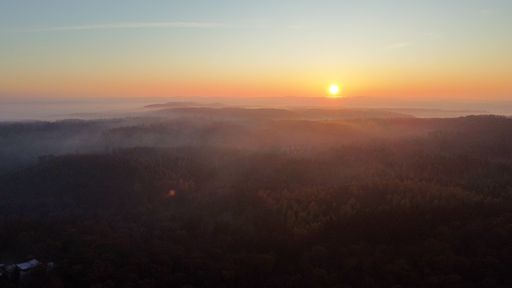 An eerie scenery of golden sunset above clouds over mountains