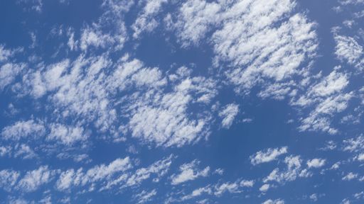 A low angle of white clouds in the blue sky on a sunny day