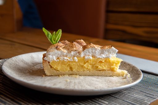 A closeup shot of a slice of cake with meringue and lemon
