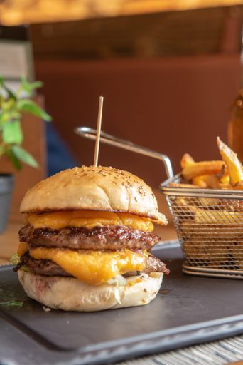 A vertical shot of a hamburger with french fries on a tray