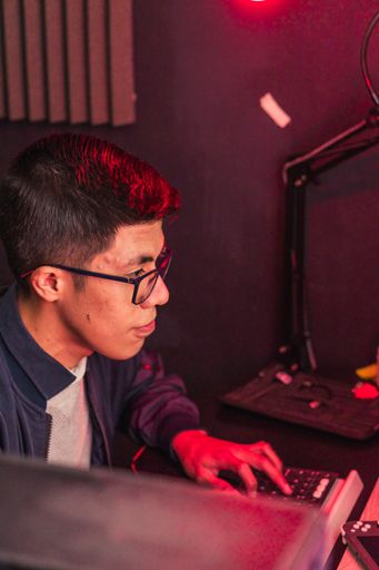 A vertical closeup shot of a young gamer male playing on his computer