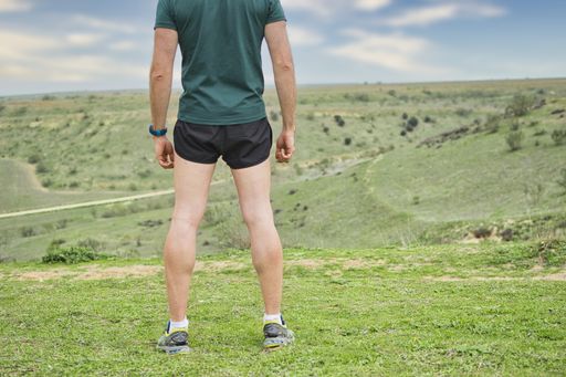A male runner taking a rest and taking a deep breath after jogging