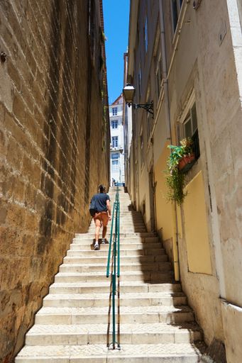 Vertical shot of old back ally stair way off the streets of Lisbon Portugal  with a local walking back home
